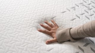 A hand placed on the Nectar Luxe mattress