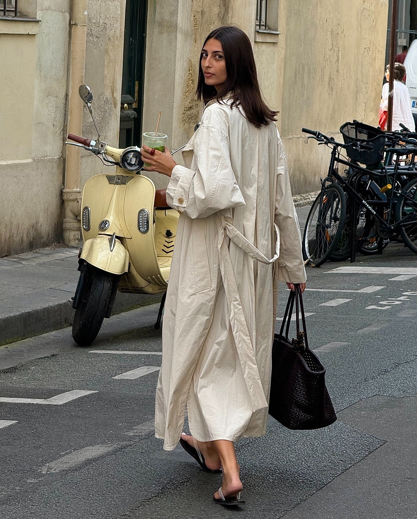 Influencer Salome wears a light beige trench coat and woven bag.