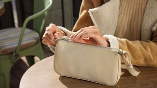 woman zipping up handbag