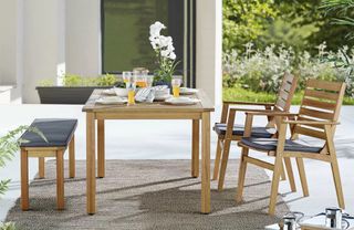 A wooden outdoor dining set with bench seat