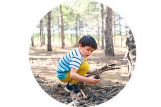 A boy picking up sticks