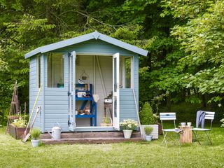 Blue potting shed made part of modern garden design