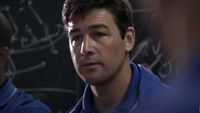 A close up of Kyle Chandler standing in front of a chalk board in Friday Night Lights. 