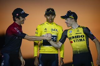 Geraint Thomas and Steven Kruijswijk shake hands in front of Egan Bernal on the Tour de France podium