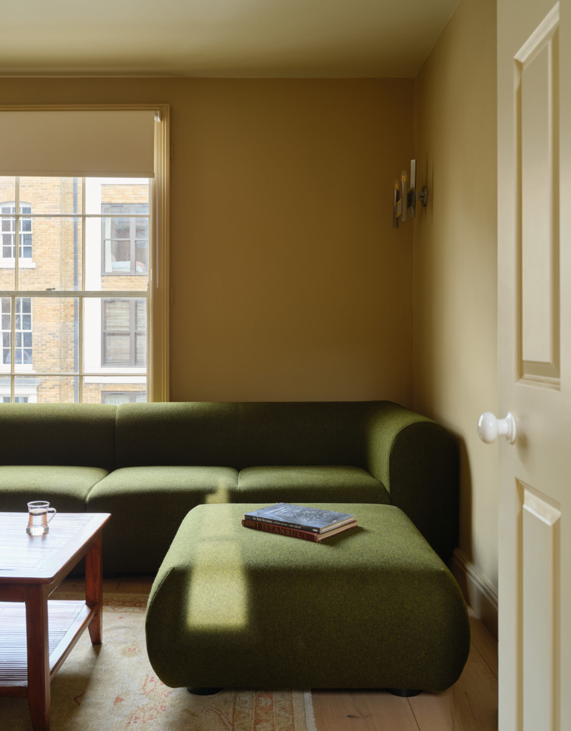 A yellow living room with a green couch