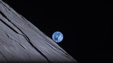 The blue marble of Earth creeps over the lunar horizon during a solar eclipse. The moon's black shadow can be seen over Australia.