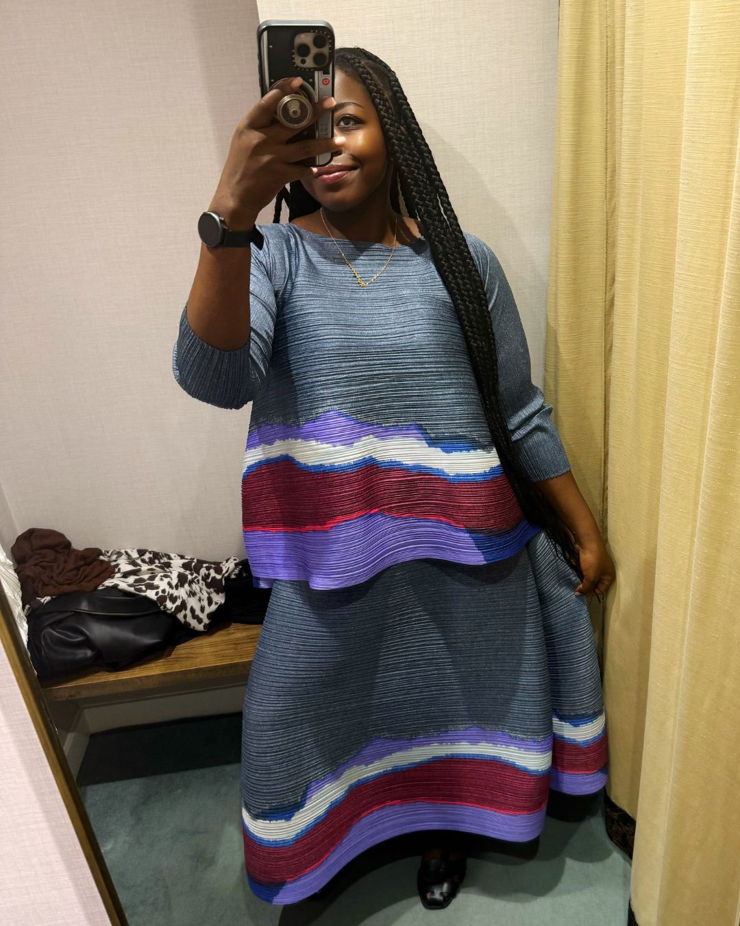 Stephanie Yeboah przymierza plisy w dużym rozmiarze. Strój Issey Miyake.