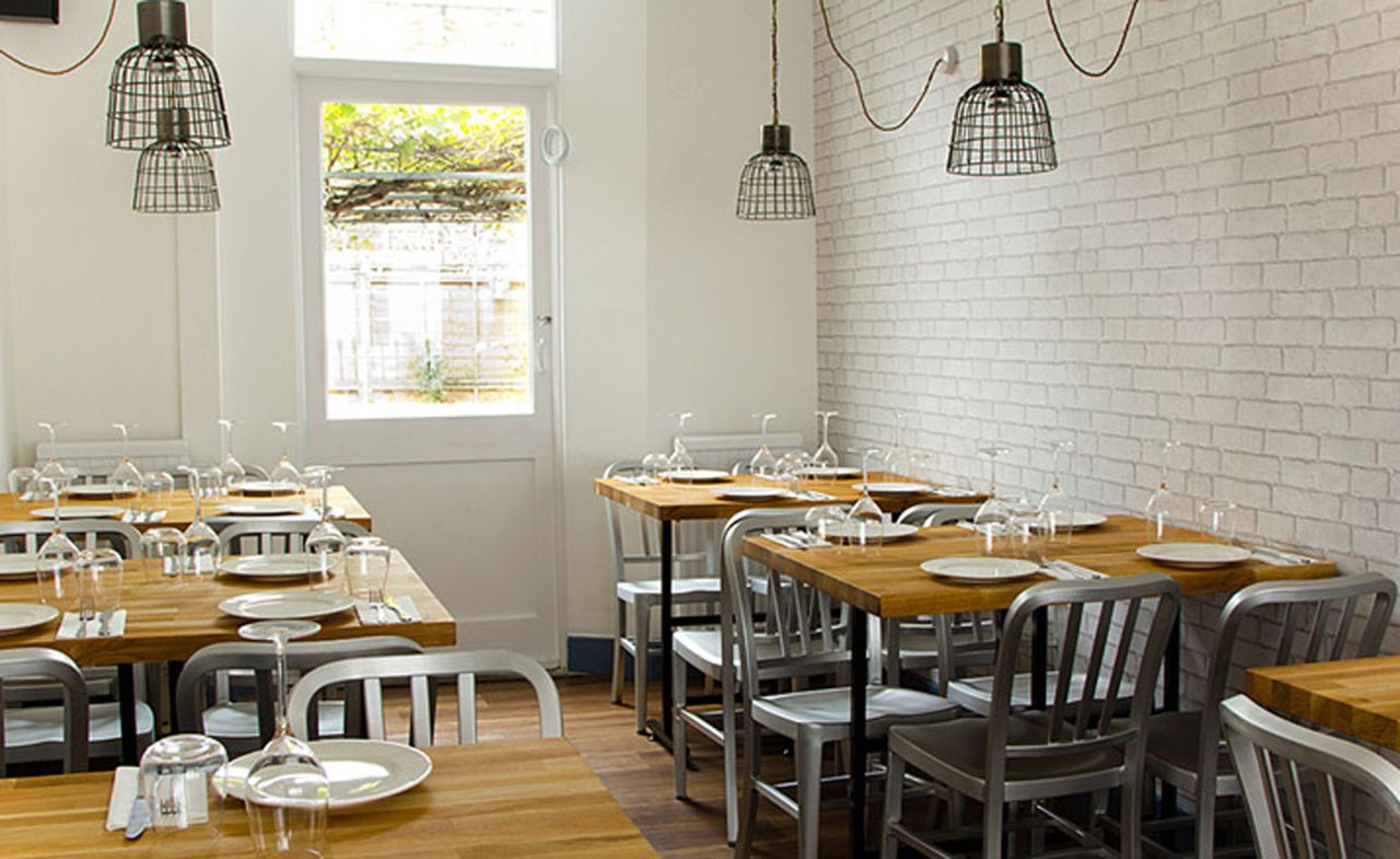 Wine glasses on wooden table and chairs at Mazi Restaurant