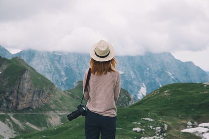 Woman standing in front of mountains alone