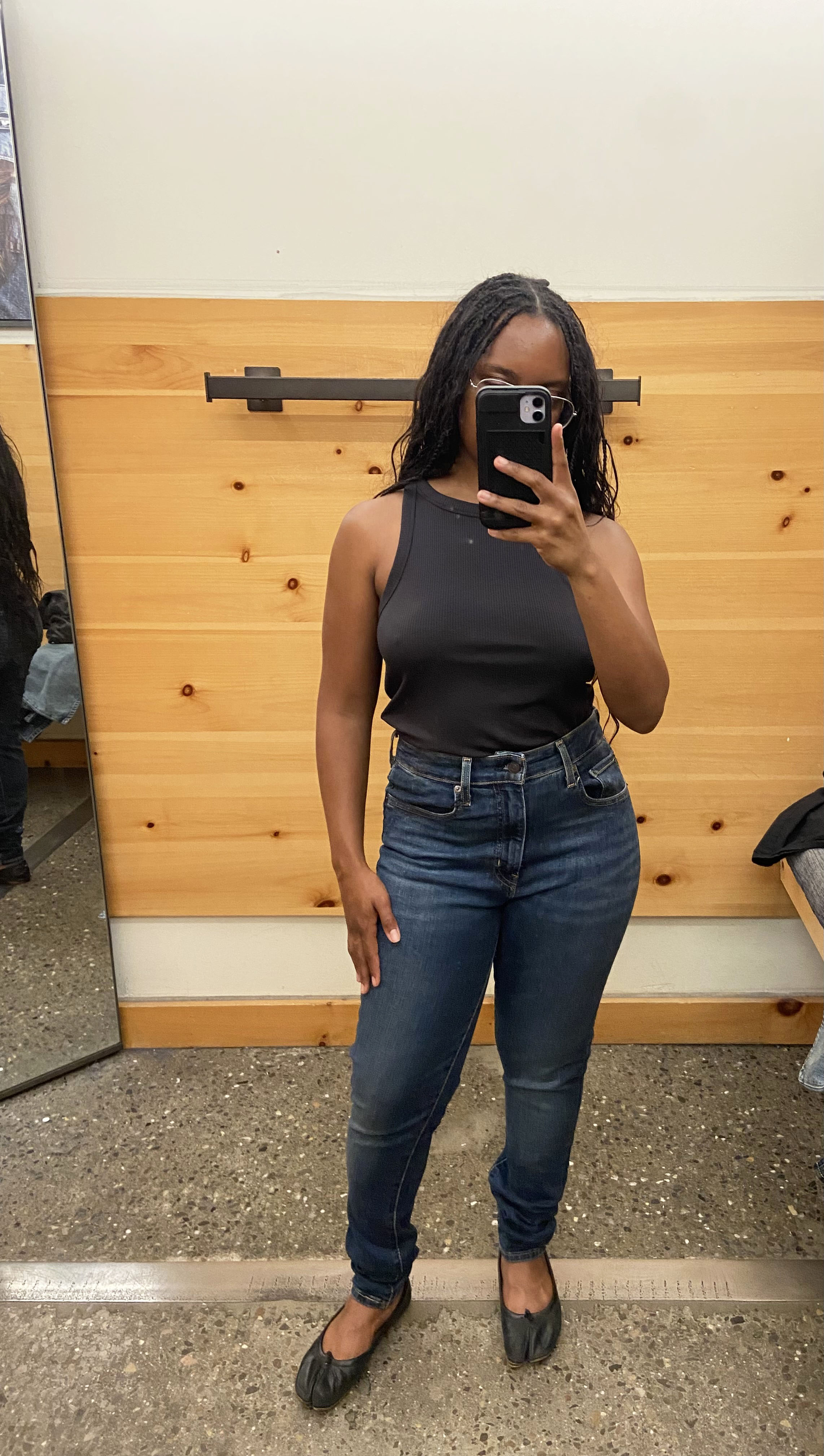 a woman wearing skinny jeans and a black tank top