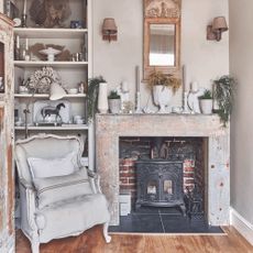 living room with wooden mantlepiece and wood-burner and armchair