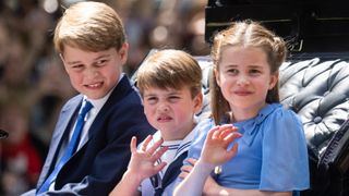 Prince George of Cambridge, Prince Louis of Cambridge and Princess Charlotte of Cambridge ride in a carriage