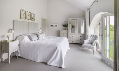 bedroom with white wall white bed cupboard and glass door