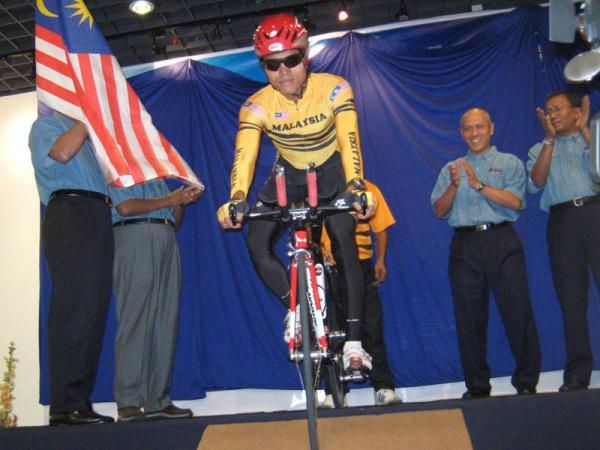 A member of the Malaysian cycling team rolls off the stage at the presentation.