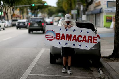Woman holds an ObamaCare sign.