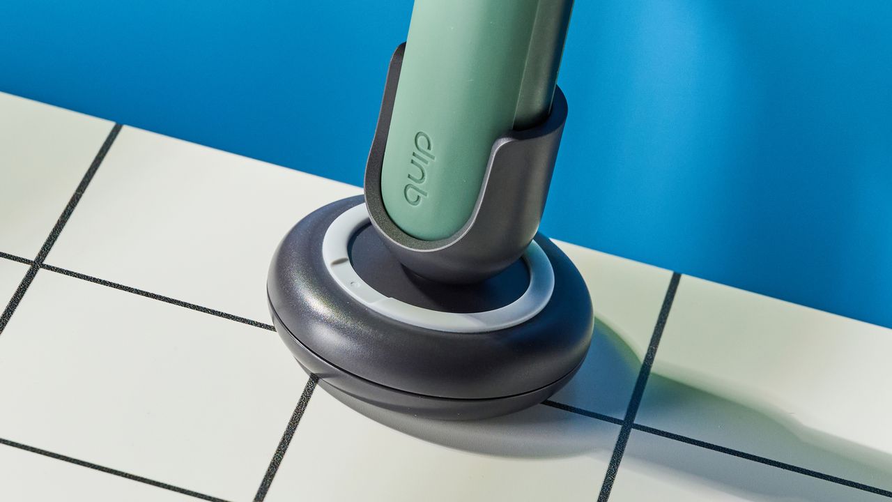Quip Ultra Next Generation Smart Sonic Electric Toothbrush photographed in front of a blue background.