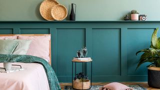 A bedroom with wood panelling behind the bed