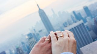 Couple holding hands against the New York City skyline backdrop