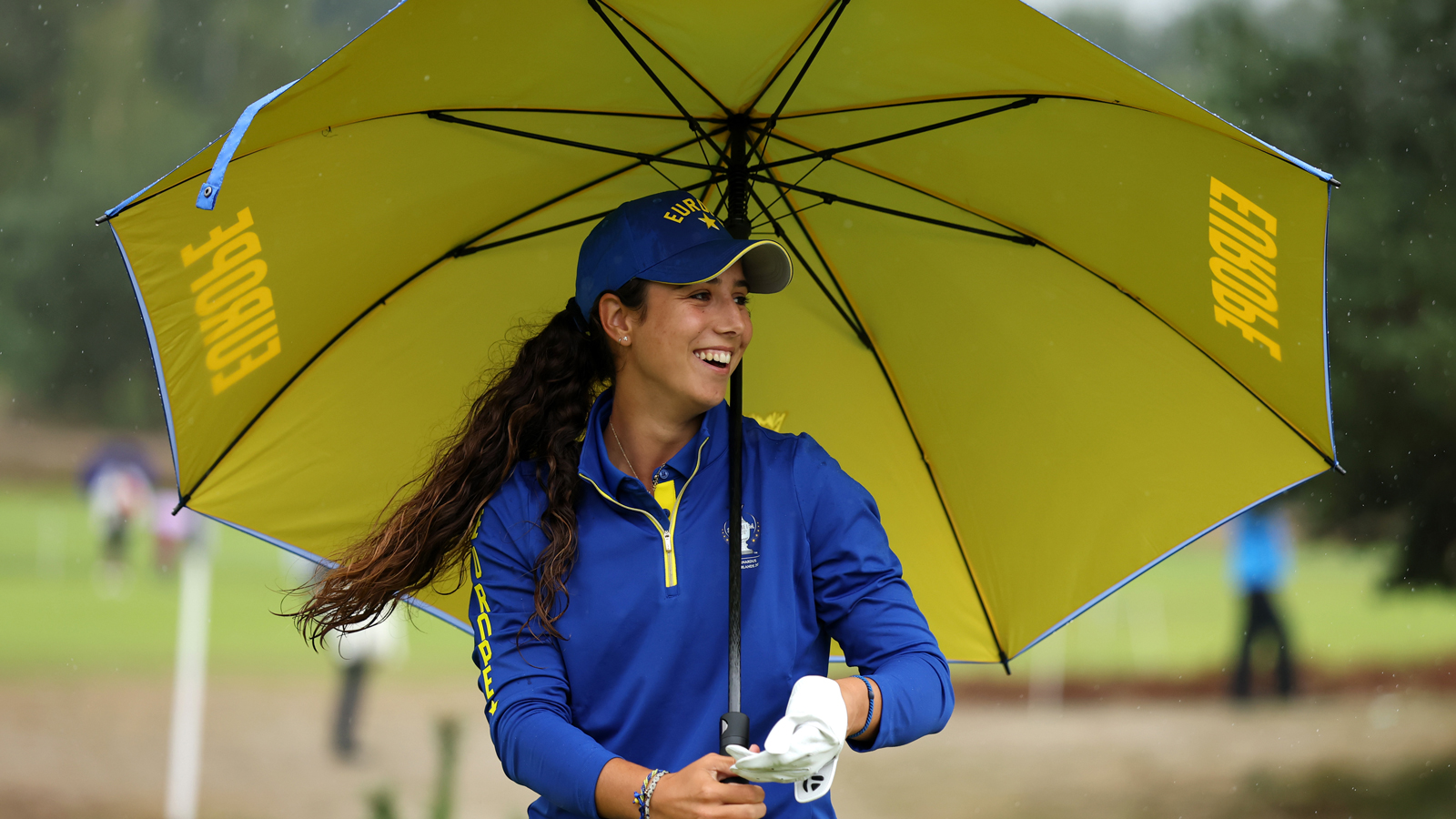 Julia Lopez Ramirez smiles under an umbrella