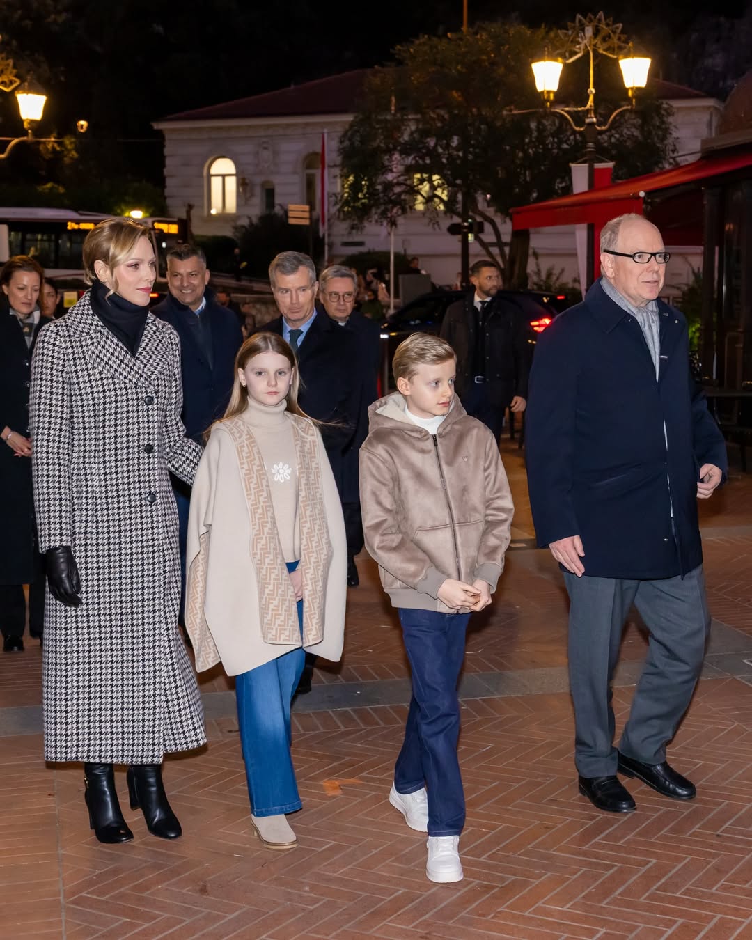 Princess Charlene, Princess Gabriella, Prince Jacques and Prince Albert walking in a row wearing coats
