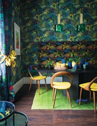 A dining room with a deep toned, heavily patterned wallpaper