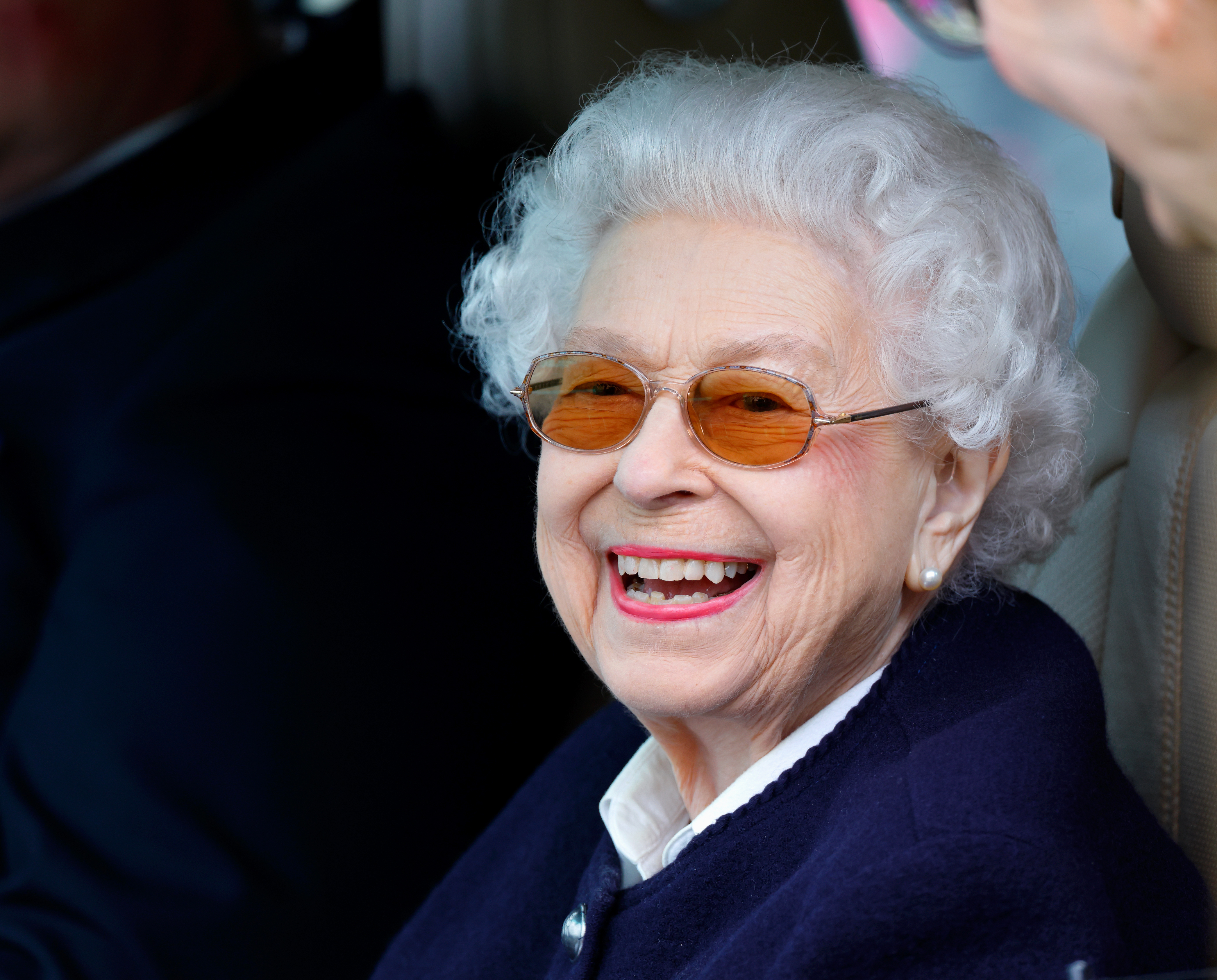 Queen Elizabeth smiling and wearing sunglasses