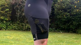 Close up of man wearing cycling bib shorts with hedge behind