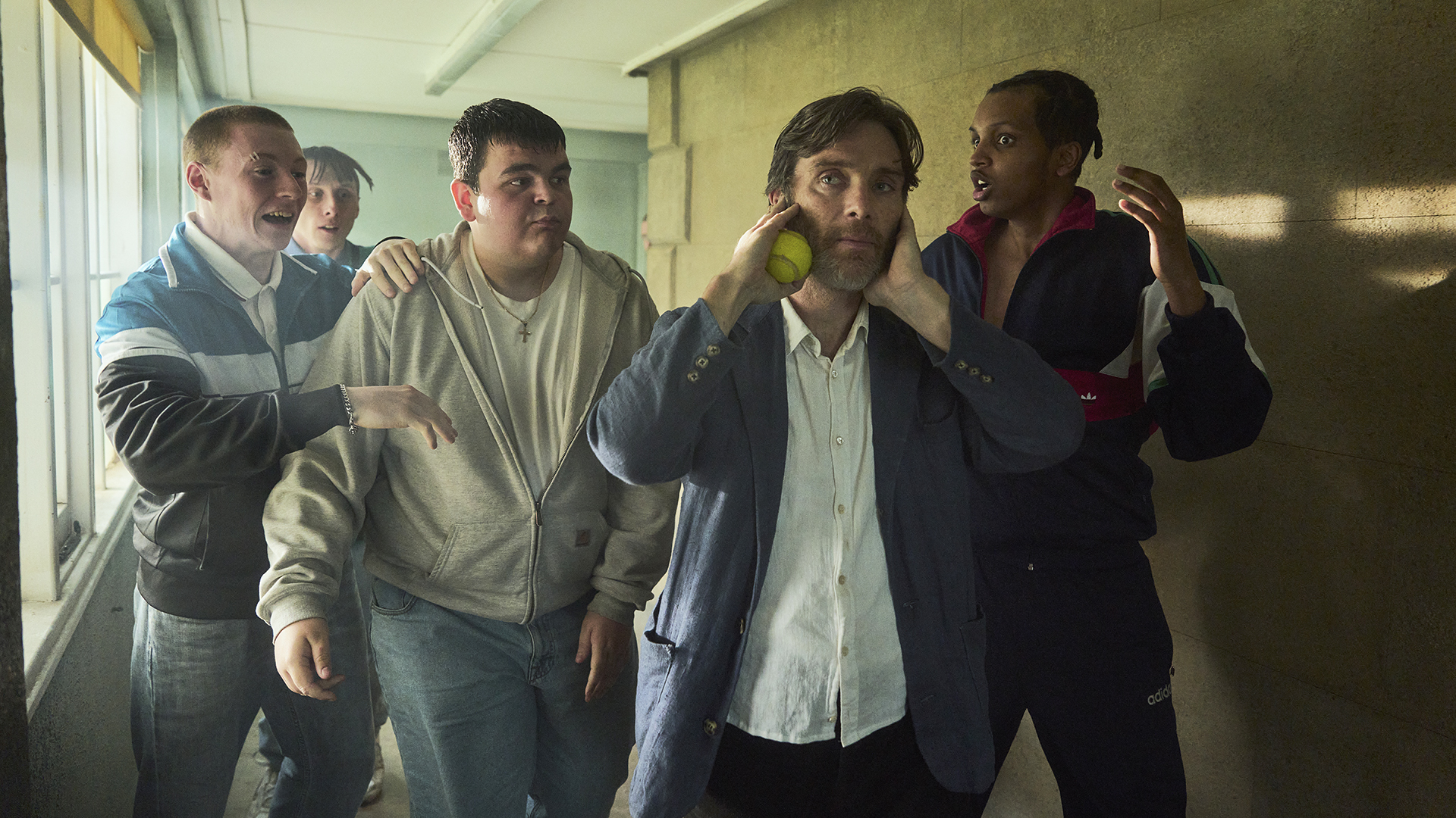 A group of young adult actors walking down a corridor with Cillian Murphy in Netflix's Steve movie