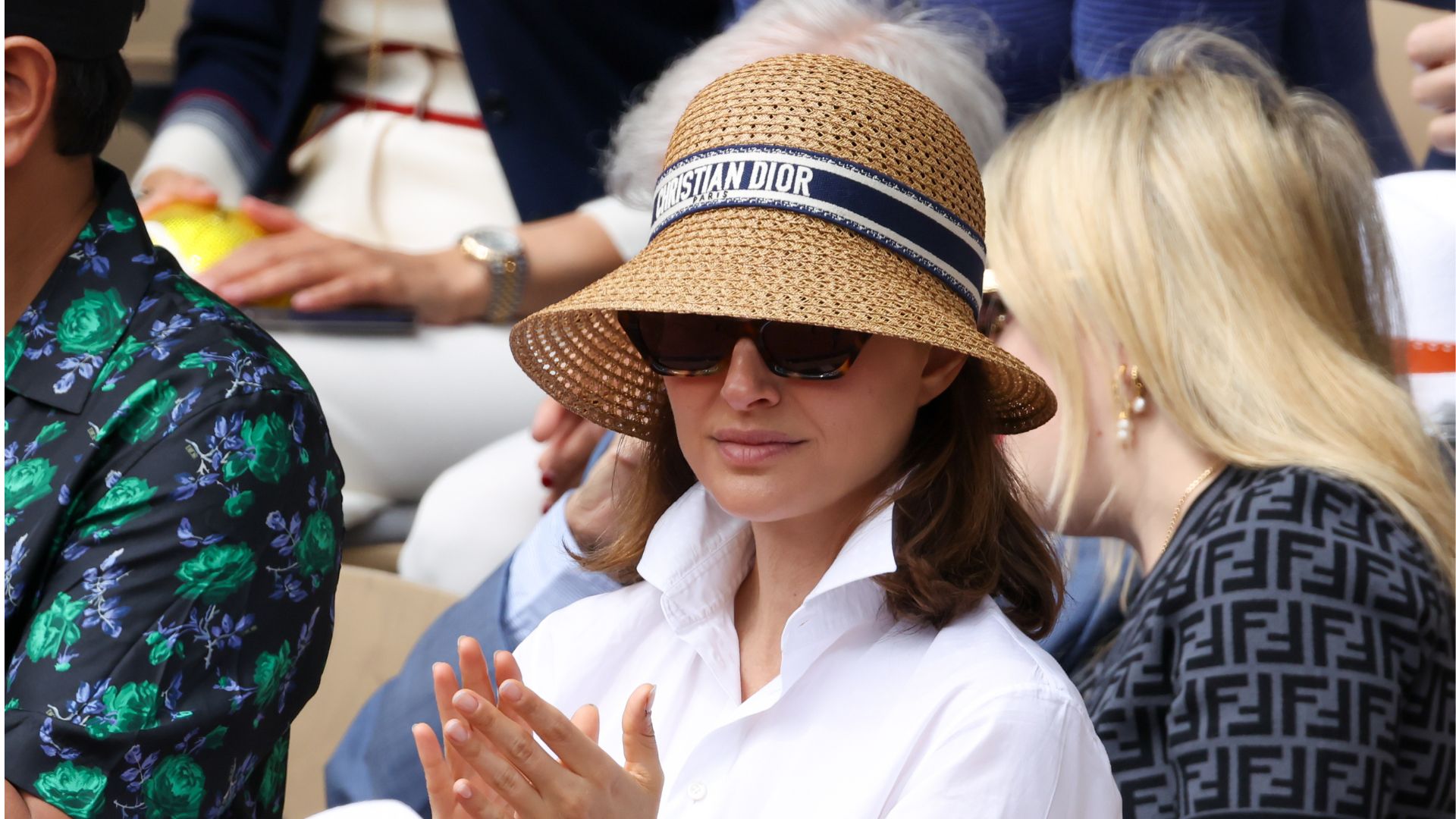 A HEADSHOT OF NATALIE PORTMAN WEARING A SHIRT AND HAT