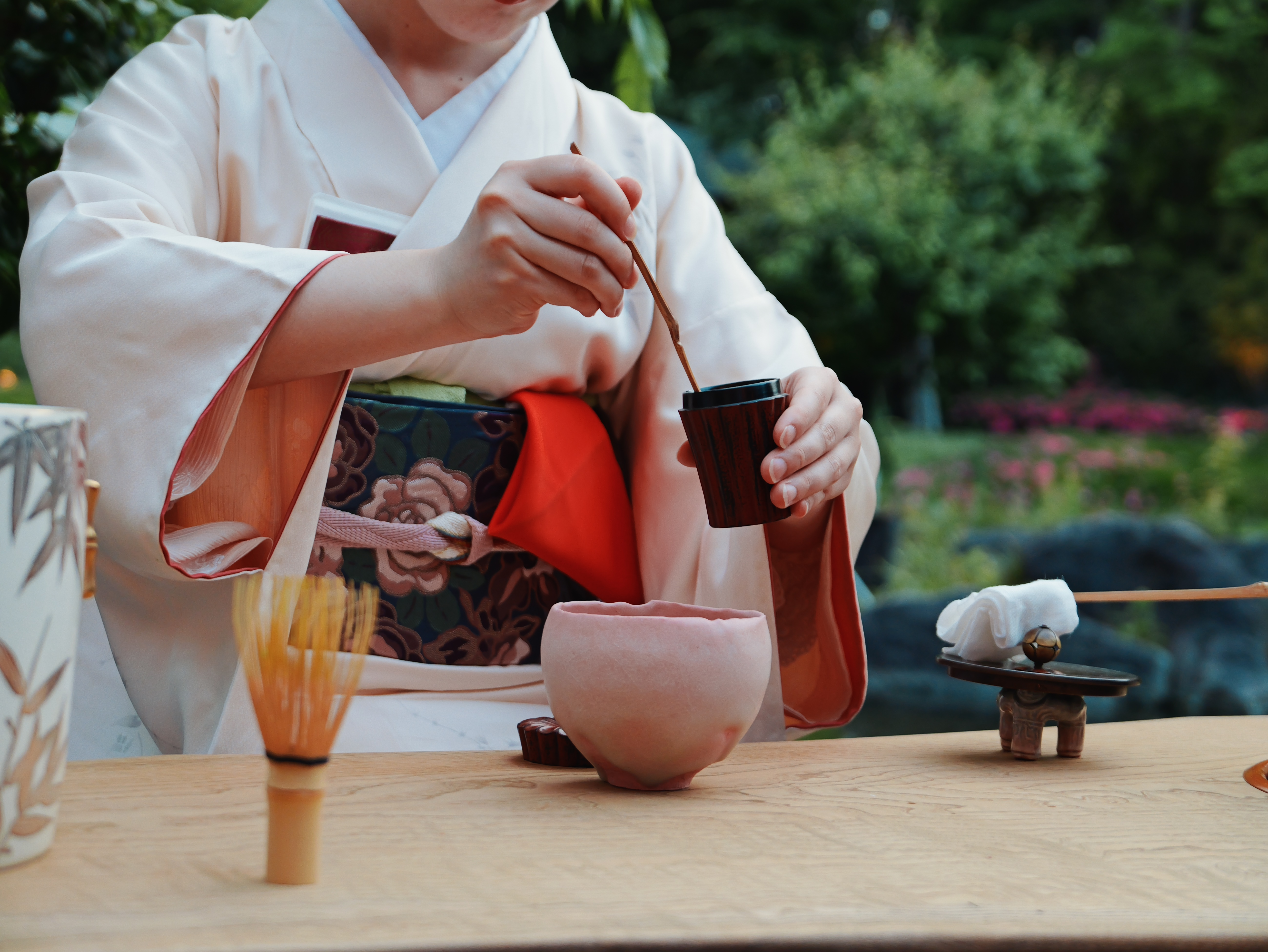 Person in kimono preparing tea in a traditional ceremony.