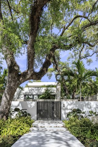 Main entrance surrounded by foliage at the Tarpon Bend Residence