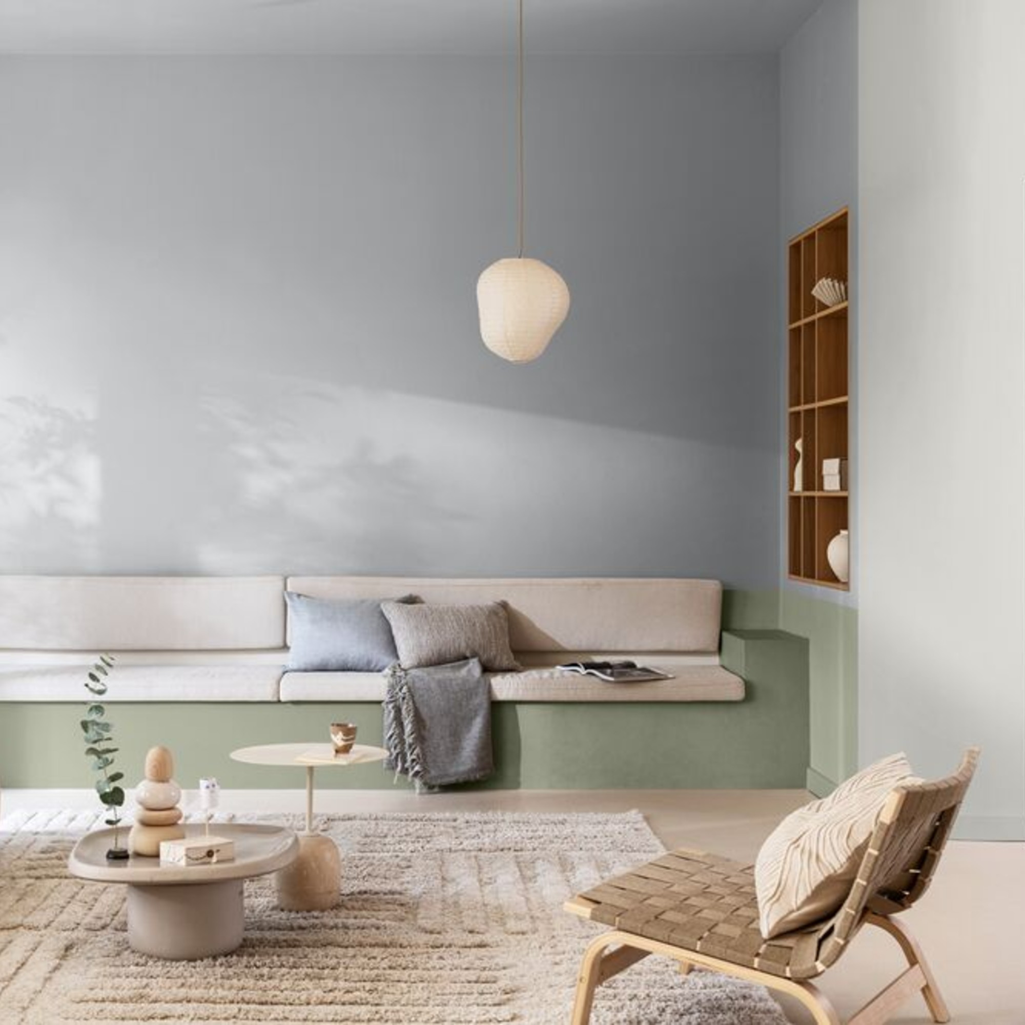 A living room painted in pale blue with a built-in sofa painted in Dulux's colour of the year 2027, Soulful Sage