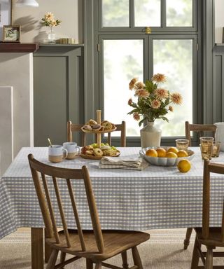 Wooden dining chairs and gingham tablecloth with diningware