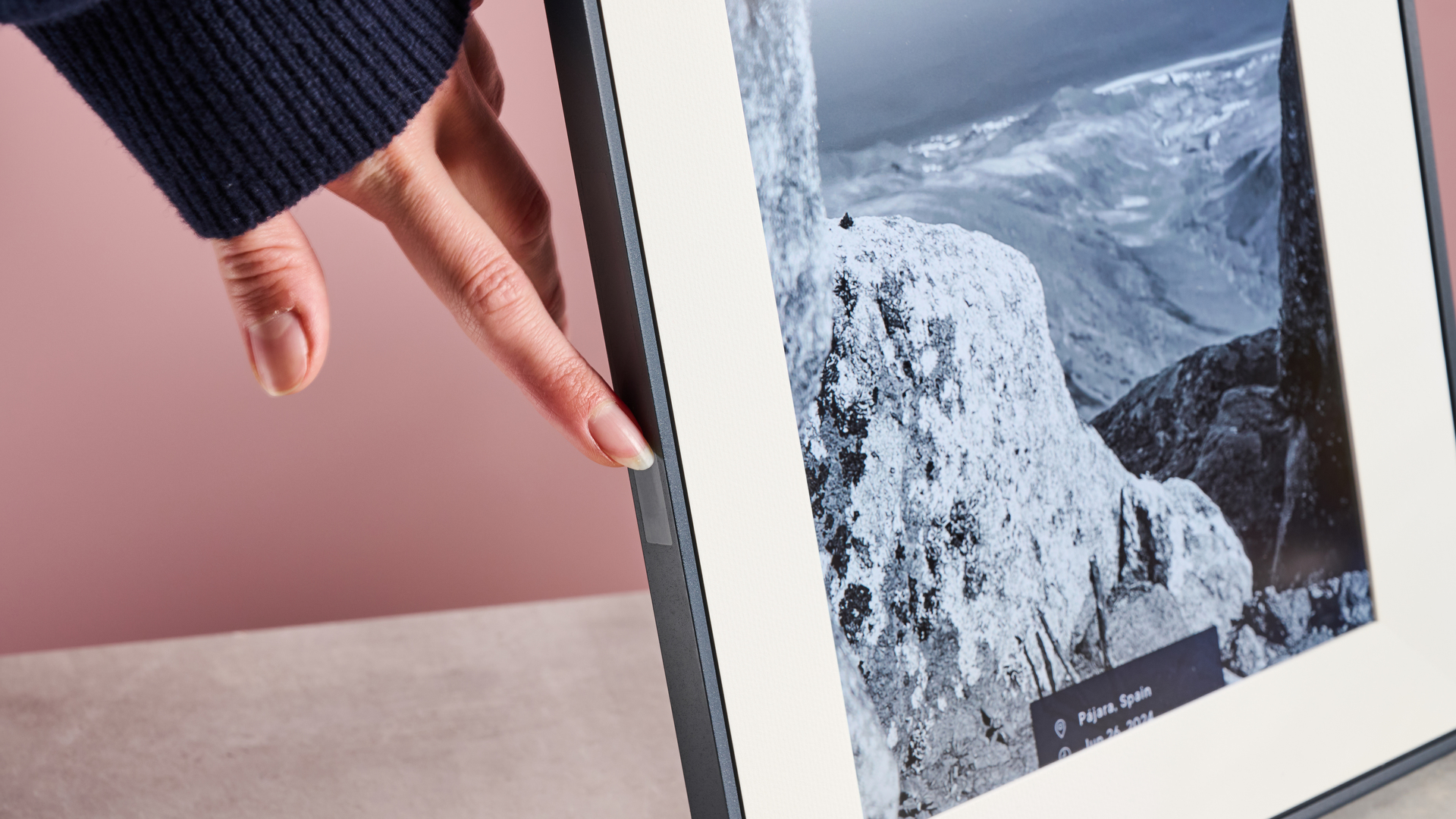 A hand swiping the touchbar on the side of the Aura Aspen.