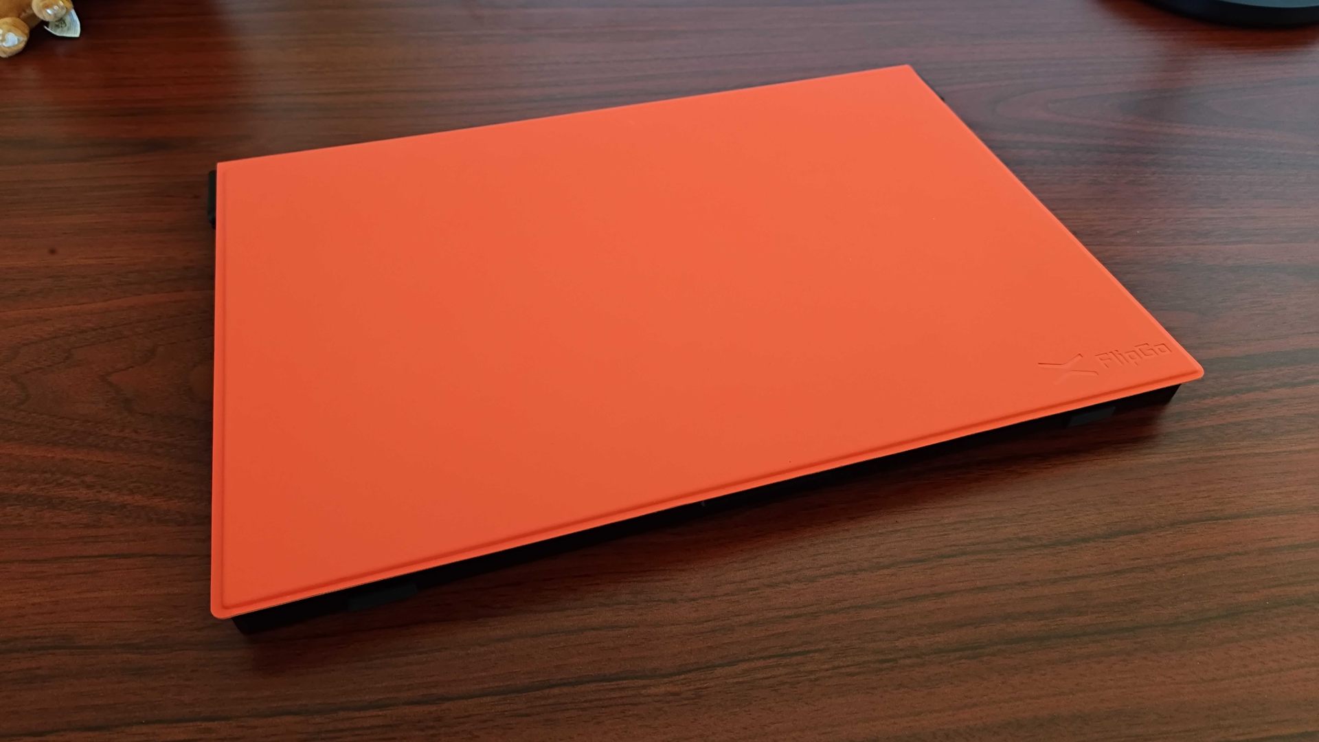 Jsaux FlipGo lying on desk with orange cover attached