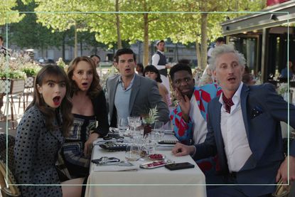 An Emily in Paris still showing Lily Collins as Emily Cooper at a dinner table with other cast members