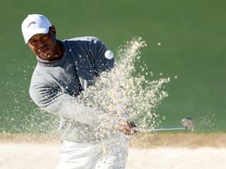 Tiger Woods hitting a bunker shot at The Masters 2024