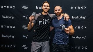 Sam Rider and race partner posing with their HYROX medals