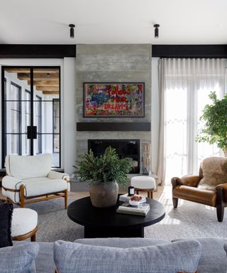 Gray living room with fireplace with art work above