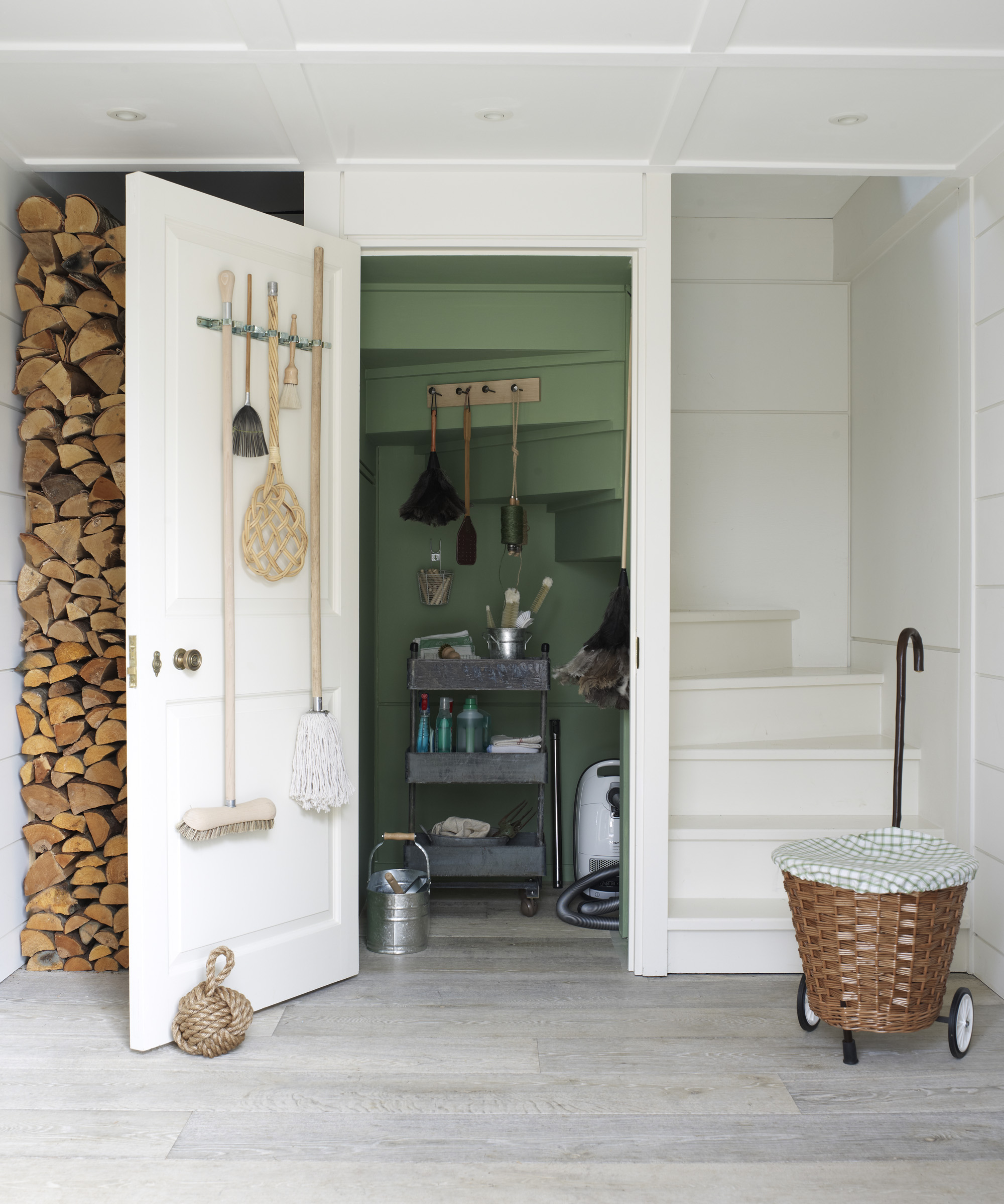 A small utility room idea with cupboard under the staircase painted green