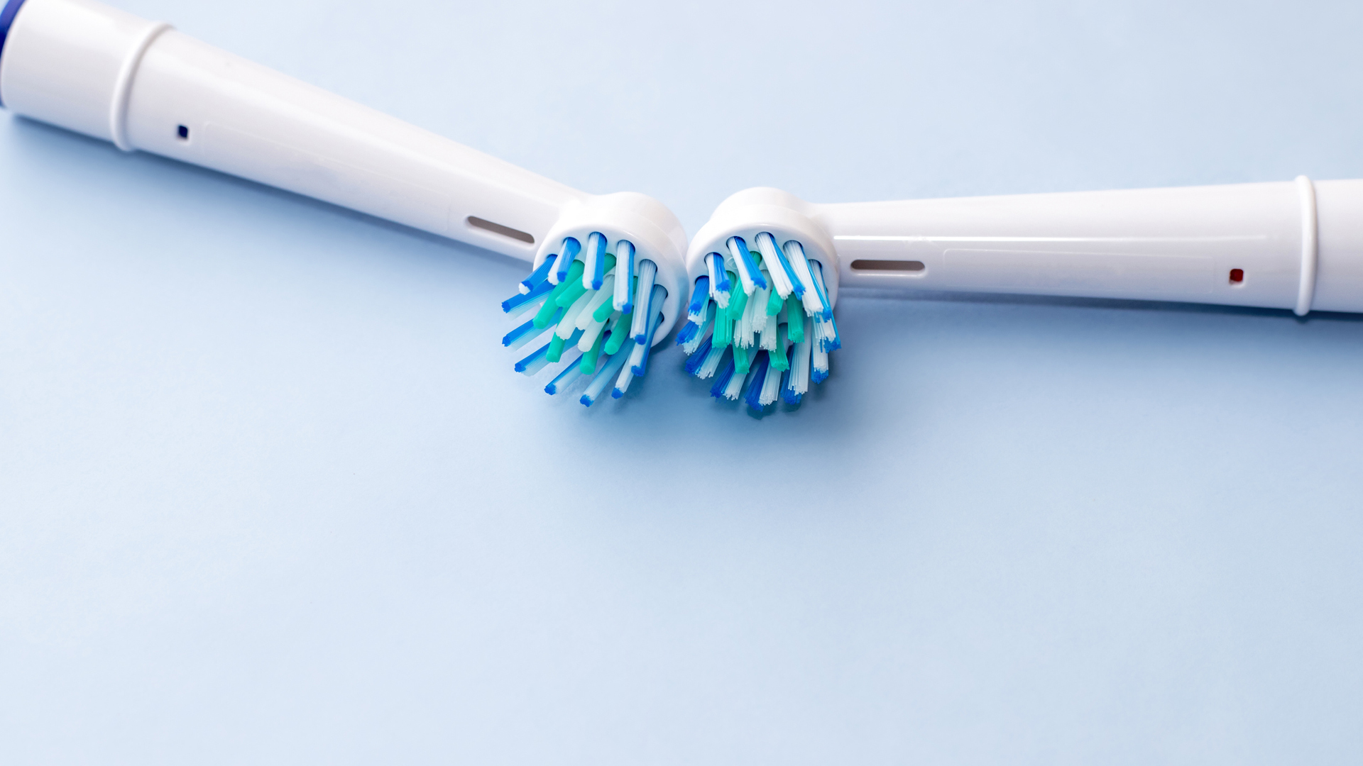 Two electric toothbrush heads laying side by side