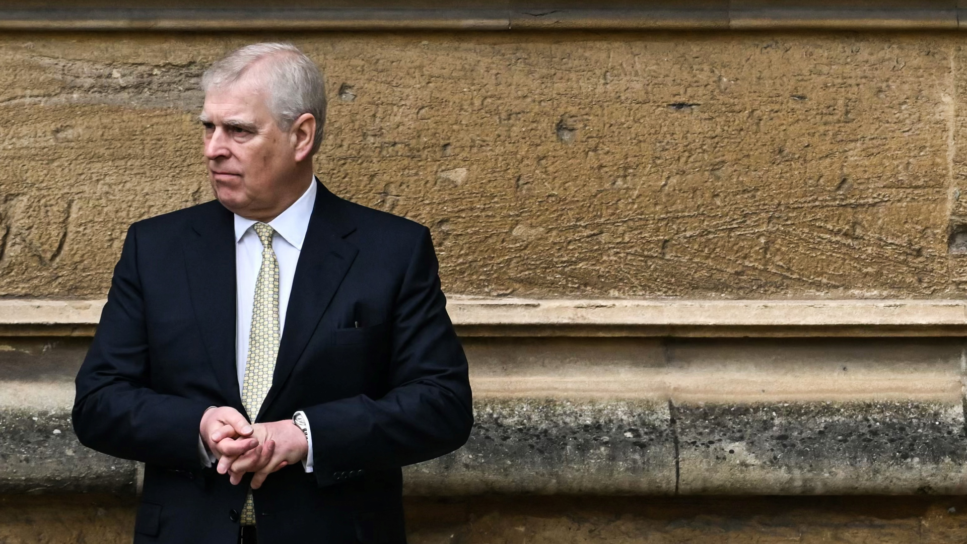 Prince Andrew standing in front of a wall