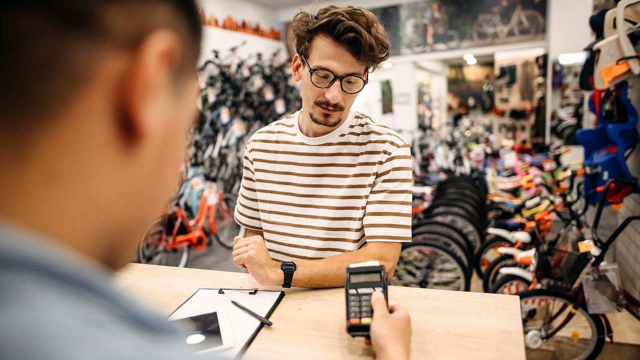 A customer makes a purchase in a bike shop 