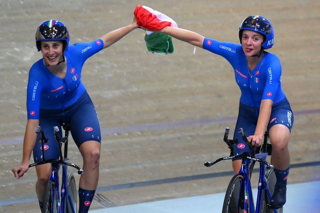 Italys Vittoria Guazzini L and Italys Martina Fidanza R celebrate their teams victory with the Italian national flag after winning the Womens Team Pursuit finals during the UCI Track Cycling World Championships at the Velodrome of SaintQuentinenYvelines southwest of Paris on October 13 2022 Photo by AnneChristine POUJOULAT AFP Photo by ANNECHRISTINE POUJOULATAFP via Getty Images