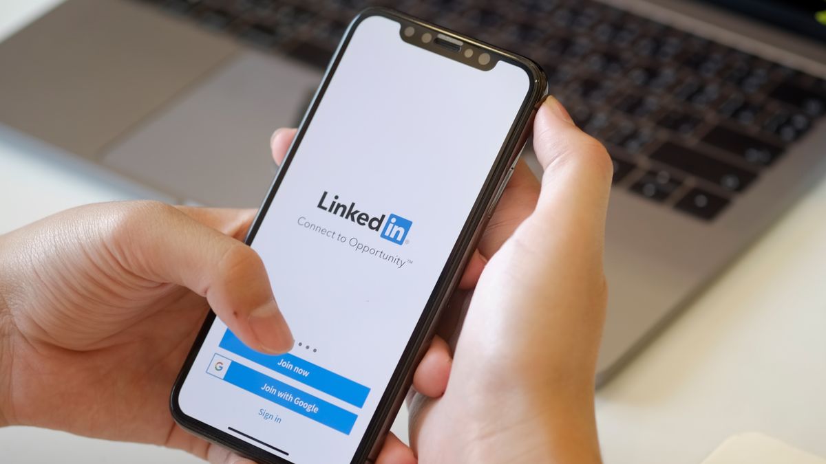 Hand holding phone with LInkedIn app