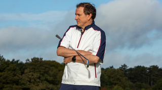 A golfer wears the Ashworth Windproof Short Sleeve 1/4 Zip