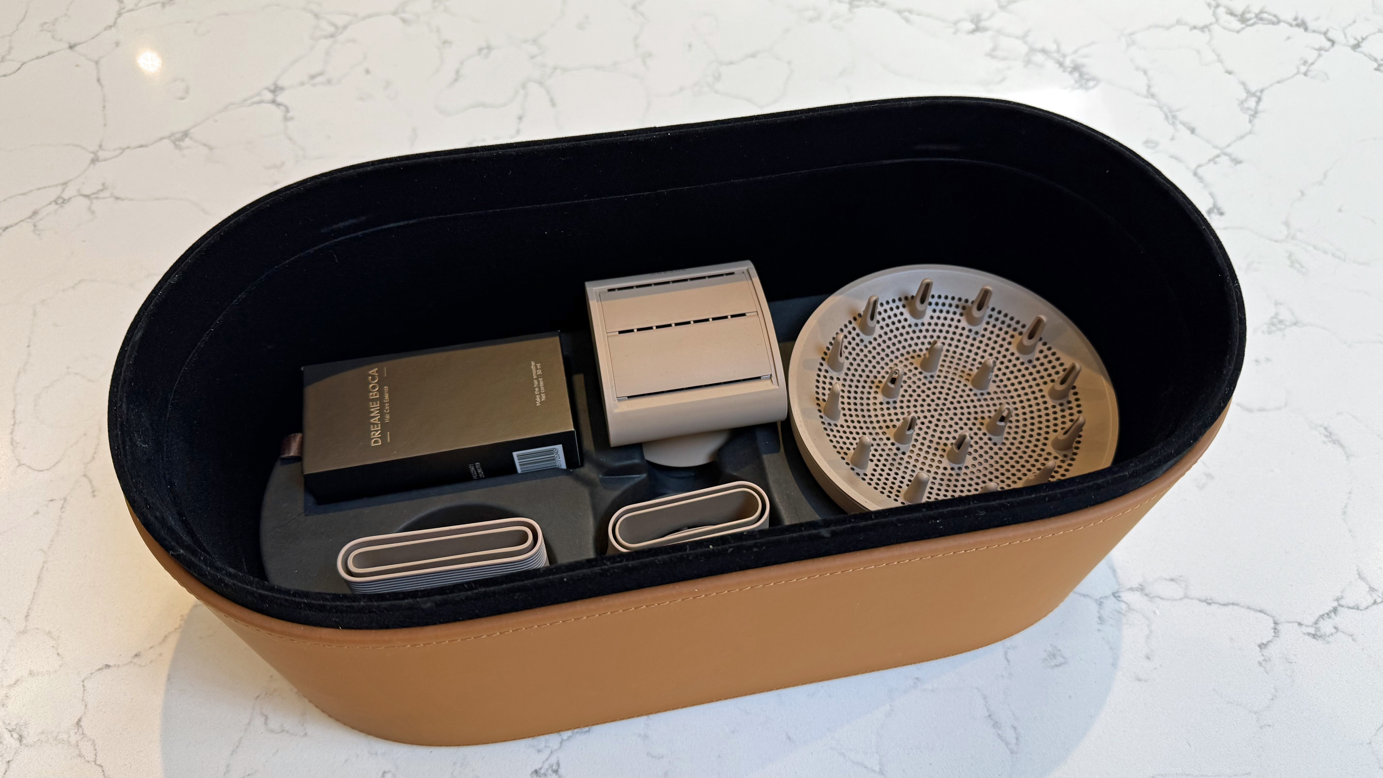 Dreame Miracle Pro attachments shown inside the tan leather storage case