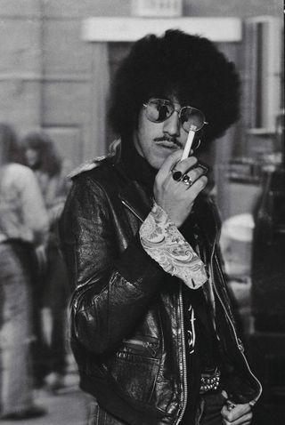 Phil Lynott in leather jacket and shades, brandishing a cigarette