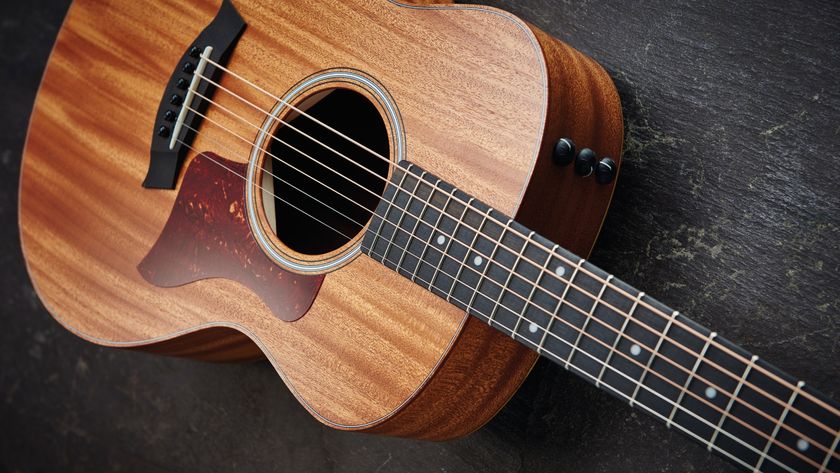 A Taylor acoustic-electric guitar lying on a wooden floor