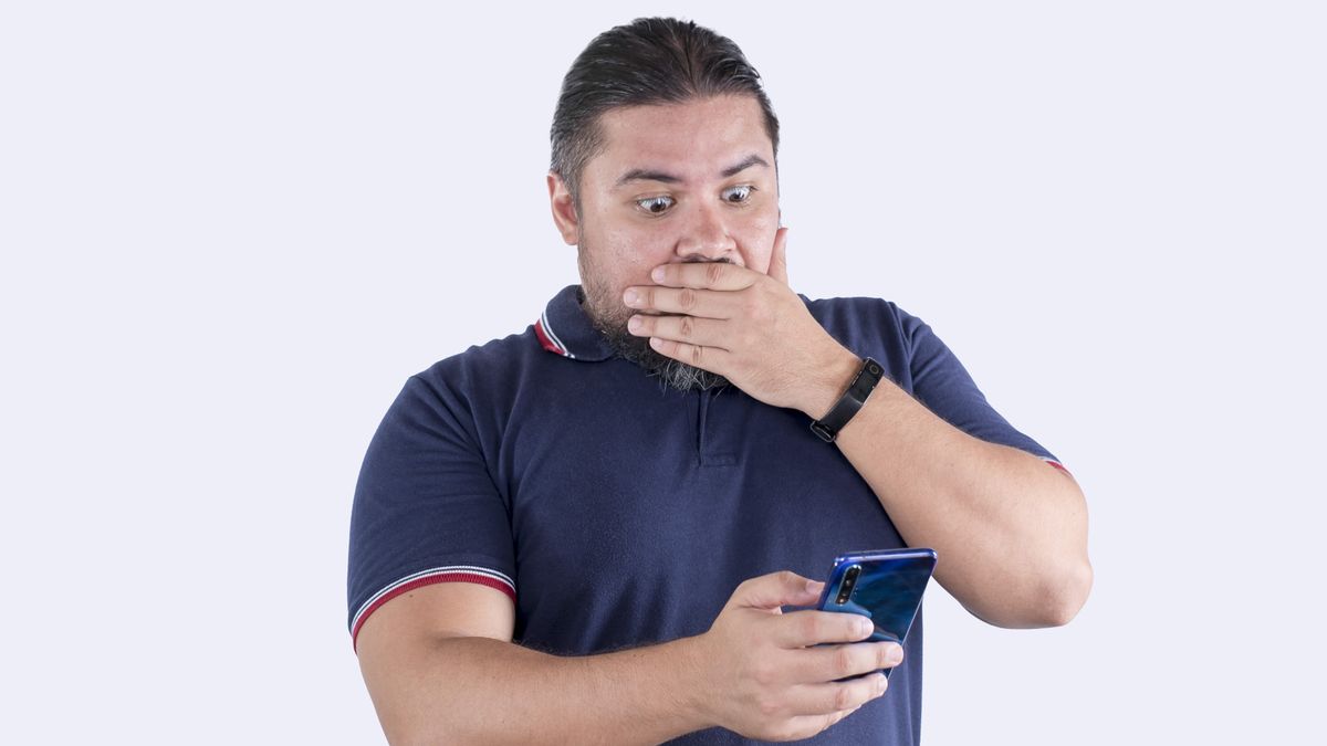 A shocked man sees something NSFW on his phone.